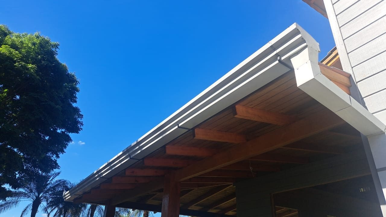 Calha de beiral em alumínio instalada sob o telhado de uma residência