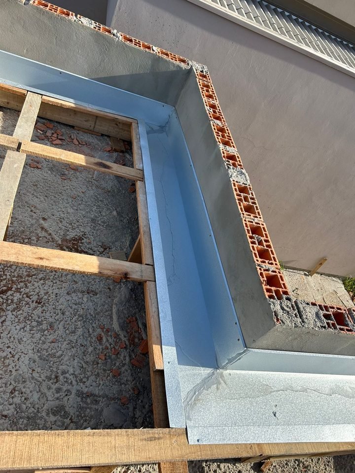 Calha interna sendo instalada na estrutura do telhado durante a obra