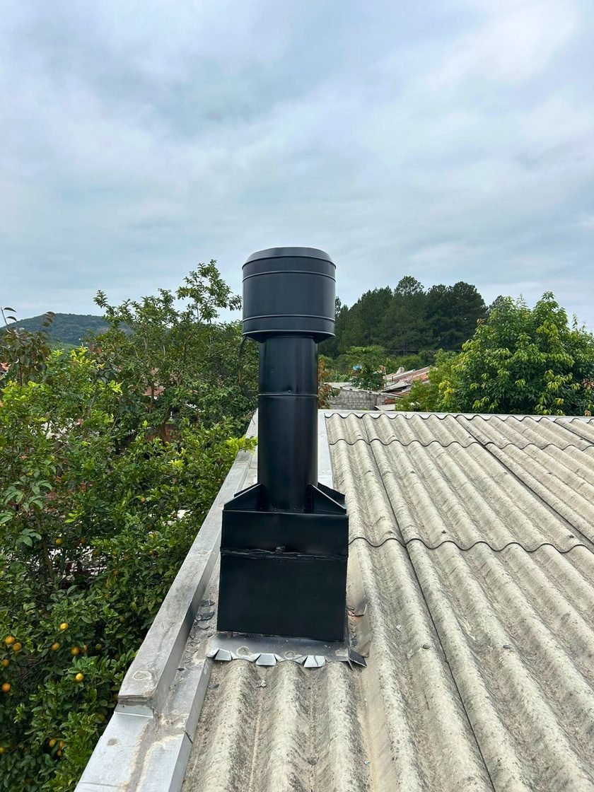 Chapéu canhão metálico protegendo a saída de duto de fumaça no telhado